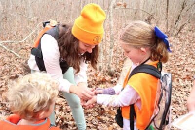 Westerly Land Trust educator, Lauren Barber, and a Girl Scout observe a salamander on a hike at Wahaneeta Preserve